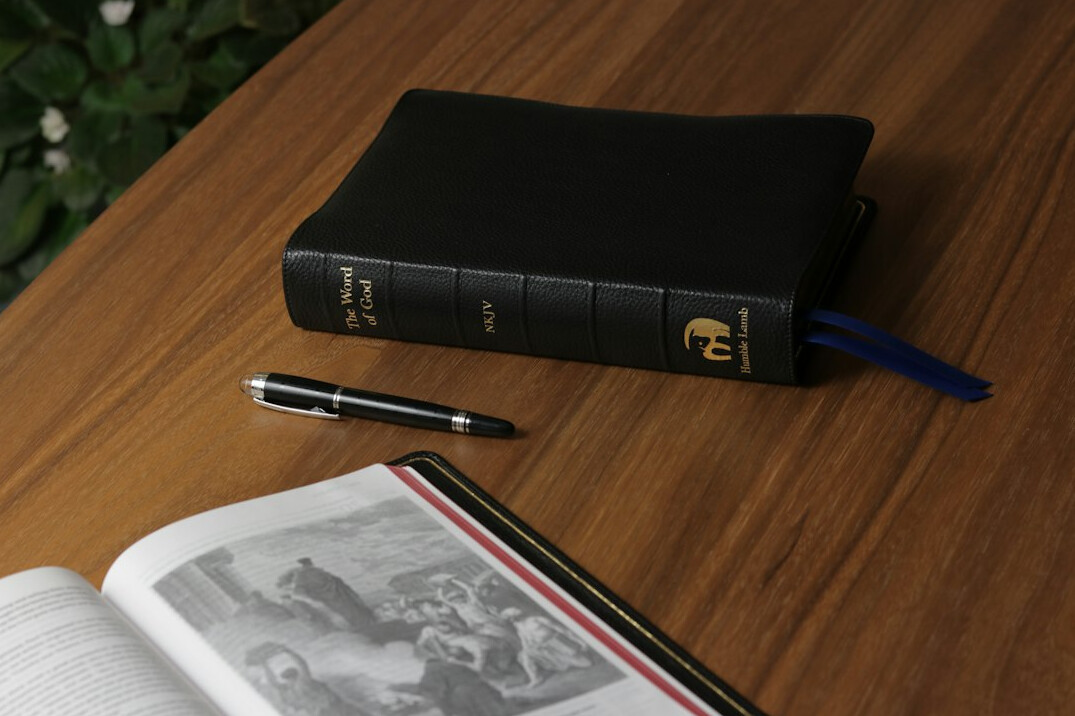 Notebook and pen on a writing desk by a window